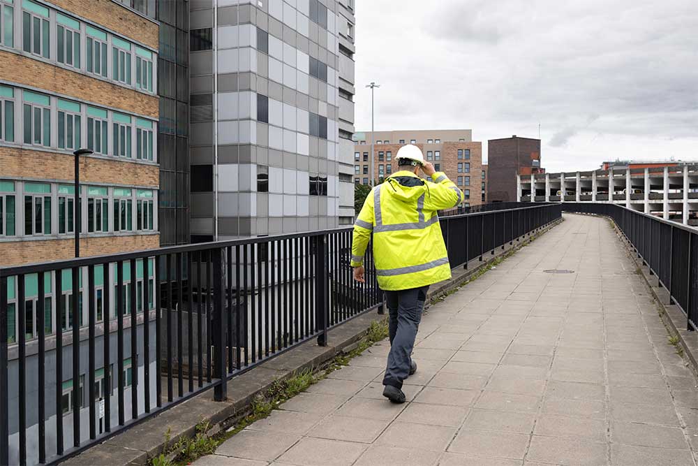 En byggarbetare som går på en väg